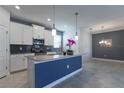 Well-lit kitchen featuring stainless steel appliances, white cabinets, and a large center island with a modern design at 11810 Imaginary Way, Orlando, FL 32832