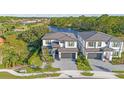 Two story home features a paved driveway, two car garage, stone accents, and manicured landscaping at 1205 Butterfly Orchid Rd, Davenport, FL 33837