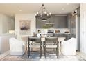 Open-concept dining area with a modern chandelier, adjacent to a kitchen with gray cabinets and stainless appliances at 13252 Sw 85Th Cir # 58, Ocala, FL 34473