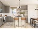 Bright kitchen with gray cabinets, stainless steel appliances, an island with seating, and an eat-in dining area at 13252 Sw 85Th Cir # 58, Ocala, FL 34473