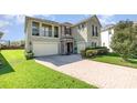 Stately two-story home with a brick-paved driveway, two-car garage, and lush green lawn at 14486 Sunbridge Cir, Winter Garden, FL 34787