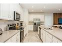 Well-lit kitchen featuring stainless steel appliances, white cabinetry and tile backsplash at 2145 Fleming Mist Pl, Kissimmee, FL 34747