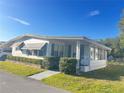 Well maintained home featuring bright white siding, an enclosed porch, manicured shrubs, and tidy landscaping at 223 Pinewood Dr, Eustis, FL 32726