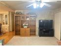 Bright living room featuring a large bookshelf, entertainment center, and neutral carpet creating a cozy atmosphere at 223 Pinewood Dr, Eustis, FL 32726