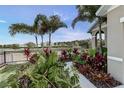 The side yard of this property features tropical landscaping and is enclosed by a black metal fence at 2271 Delhi Pl, Sanford, FL 32771