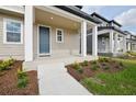 Inviting front porch with columns, manicured landscaping, blue door and sidewalk at 2354 Broadbrook Dr, St Cloud, FL 34771