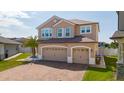 Charming two-story home featuring a three-car garage and a brick paver driveway at 2424 Varenna Loop, Kissimmee, FL 34741
