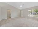 Bright, spacious living room featuring vaulted ceilings, new carpet, and a ceiling fan at 36 Se Almond Dr, Ocala, FL 34472