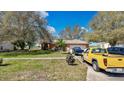 Inviting single-story home with a well-manicured lawn, mature trees, and a convenient two-car garage at 37149 Sandy Ln, Grand Island, FL 32735