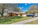 Lovely single-story home with a lush green lawn, mature trees, and an attached two-car garage at 37149 Sandy Ln, Grand Island, FL 32735