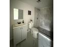 Bathroom featuring gray tiling in the shower, modern vanity, stylish fixtures and marble-look tile flooring at 3931 Avenue R Nw, Winter Haven, FL 33881
