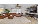 Comfortable living area featuring a large leather sectional, ceiling fan, and built-in media console at 415 Flagler Rd, Winter Haven, FL 33884