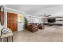 Spacious living room featuring a large leather sectional, tile floors, and a decorative rug at 415 Flagler Rd, Winter Haven, FL 33884