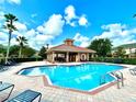 Community pool with a pool house and lounge chairs, perfect for relaxation at 604 Fortanini Cir, Ocoee, FL 34761