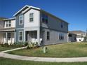 Two-story townhome featuring light gray and dark gray siding, and a well-maintained lawn at 6147 Arbor Watch Loop, Orlando, FL 32829