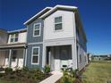 Charming two-story townhome with light gray and dark gray siding, neat landscaping and covered entry at 6147 Arbor Watch Loop, Orlando, FL 32829