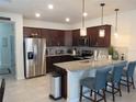 Stylish kitchen with stainless steel appliances, granite countertops, a breakfast bar, and pendant lighting at 6147 Arbor Watch Loop, Orlando, FL 32829