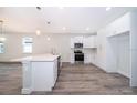 Bright, open kitchen with modern appliances, a large island with a sink, and sleek white cabinetry at 1104 Grove Manor Dr, Sanford, FL 32771
