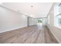 Bright living room with modern chandelier, hardwood floors, and sliding glass doors to the backyard at 1104 Grove Manor Dr, Sanford, FL 32771
