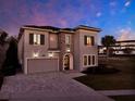 Charming two-story home featuring stone accents, a paver driveway, and exterior lighting at 1281 Grand Traverse Pkwy, Reunion, FL 34747