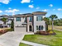 Beautiful two-story home featuring stone accents, a paver driveway, and mature landscaping at 1281 Grand Traverse Pkwy, Reunion, FL 34747