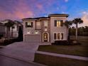 Charming two-story home featuring stone accents, a paver driveway, and exterior lighting at 1281 Grand Traverse Pkwy, Reunion, FL 34747