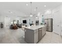 Open-concept kitchen with a large center island, stainless steel appliances, and modern finishes at 13759 Mommsen Ave, Orlando, FL 32827