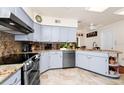 A functional kitchen with granite countertops, stainless steel appliances, and light blue cabinets at 1532 Lake Shore Dr, Orlando, FL 32803