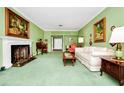 A classic living room with a fireplace, green walls, and traditional furnishings at 1532 Lake Shore Dr, Orlando, FL 32803