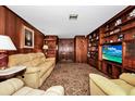 Cozy living room featuring wood paneling, built-in shelves, and comfortable seating at 1532 Lake Shore Dr, Orlando, FL 32803