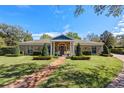 Charming brick home with manicured lawn, brick pathway, and lush landscaping, creating inviting curb appeal at 1600 Barcelona Way, Winter Park, FL 32789