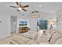 Bright living room with tile flooring, ceiling fan, and sliding door to the backyard at 19624 E Umatilla Blvd, Umatilla, FL 32784