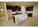 Open kitchen with a large center island, dark cabinets, stainless appliances, and light countertop at 1995 Iorio St, St Cloud, FL 34771