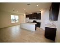 Bright kitchen and dining area with tile floors, dark cabinets, and stainless steel appliances at 1995 Iorio St, St Cloud, FL 34771
