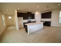 Spacious kitchen with center island, dark cabinets, stainless appliances, and light countertops at 1995 Iorio St, St Cloud, FL 34771