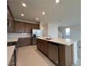 Modern kitchen featuring an island with a sink, stainless steel appliances, and tiled backsplash at 1996 Heart Lake Dr, Groveland, FL 34736