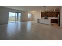 Open-concept living room and kitchen area with tile floors and sliding glass doors at 1996 Heart Lake Dr, Groveland, FL 34736