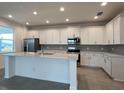 Bright kitchen featuring white cabinets, stainless steel appliances, and a center island at 2000 Heart Lake Dr, Groveland, FL 34736