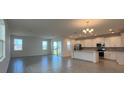 Open-concept living room and kitchen area with tiled flooring and abundant natural light at 2000 Heart Lake Dr, Groveland, FL 34736
