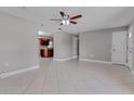Open-concept living room with tile flooring, ceiling fan, and a view into the kitchen area at 2102 Nedra Ave, Deltona, FL 32725