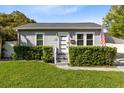 Charming single-story home with gray siding, manicured hedges, and a well-maintained lawn at 211 E Muriel St, Orlando, FL 32806