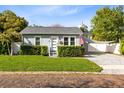 Charming home featuring gray siding, manicured hedges, and a brick-paved driveway at 211 E Muriel St, Orlando, FL 32806