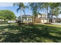 Landscaped front yard featuring a spacious lawn, mature trees, and a charming two-story home at 2523 Water Valley Dr, St Cloud, FL 34771