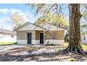 Charming single-Gathering home featuring dual entry doors, neutral paint, and a mature shade tree at 2605 S Elm Ave, Sanford, FL 32773