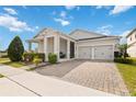 Inviting single-story home boasts a paved driveway leading to a two-car garage and covered front porch at 2951 Irish Peach Dr, Winter Garden, FL 34787