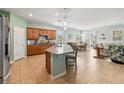 Bright kitchen with island, granite countertops, wooden cabinets, stainless appliances, flowing into the living and dining areas at 2951 Irish Peach Dr, Winter Garden, FL 34787