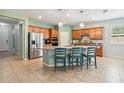 Spacious kitchen with wood cabinets, granite counters, stainless steel appliances and a center island with bar stool seating at 2951 Irish Peach Dr, Winter Garden, FL 34787