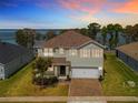 Charming two-story home boasting a paver driveway and lush landscaping at 3279 Landing Vw, Tavares, FL 32778