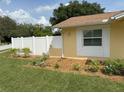 A close up of the side of a single-story home with a white picket fence and some flower beds at 333 Crystal Cir, Oviedo, FL 32765