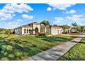 A lush green lawn surrounds this beautiful single story home with a three car garage and tile roof at 3707 Paradiso Cir, Kissimmee, FL 34746